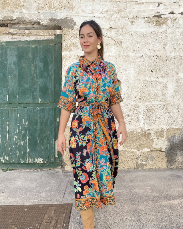 Mujer con vestido midi de otoño, estampado, de corte camisero, abotonado con cinto de lazada en la misma tela