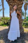 Mujer joven rubia con vestido largo blanco de estilo ibicenco boho chic, cuello Halter y espalda descubierta.