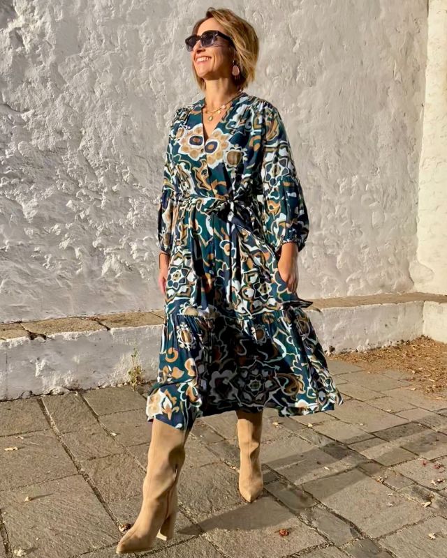 Mujer de 50 años con vestido camisero de otoño estampado, en tonos azules y tierras. Tejido fluido. Cinturón en la misma tela.
