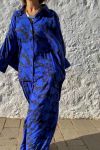 Mujer vestida con conjunto oversize de blusón y palazzo, estampado en fondo azulón y dibujos en negro, de esencia boho chic