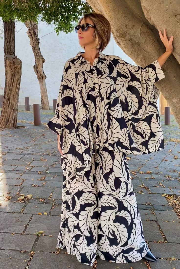 Mujer vestida con conjunto oversize de blusón y palazzo, estampado en blanco y negro, de esencia boho chic